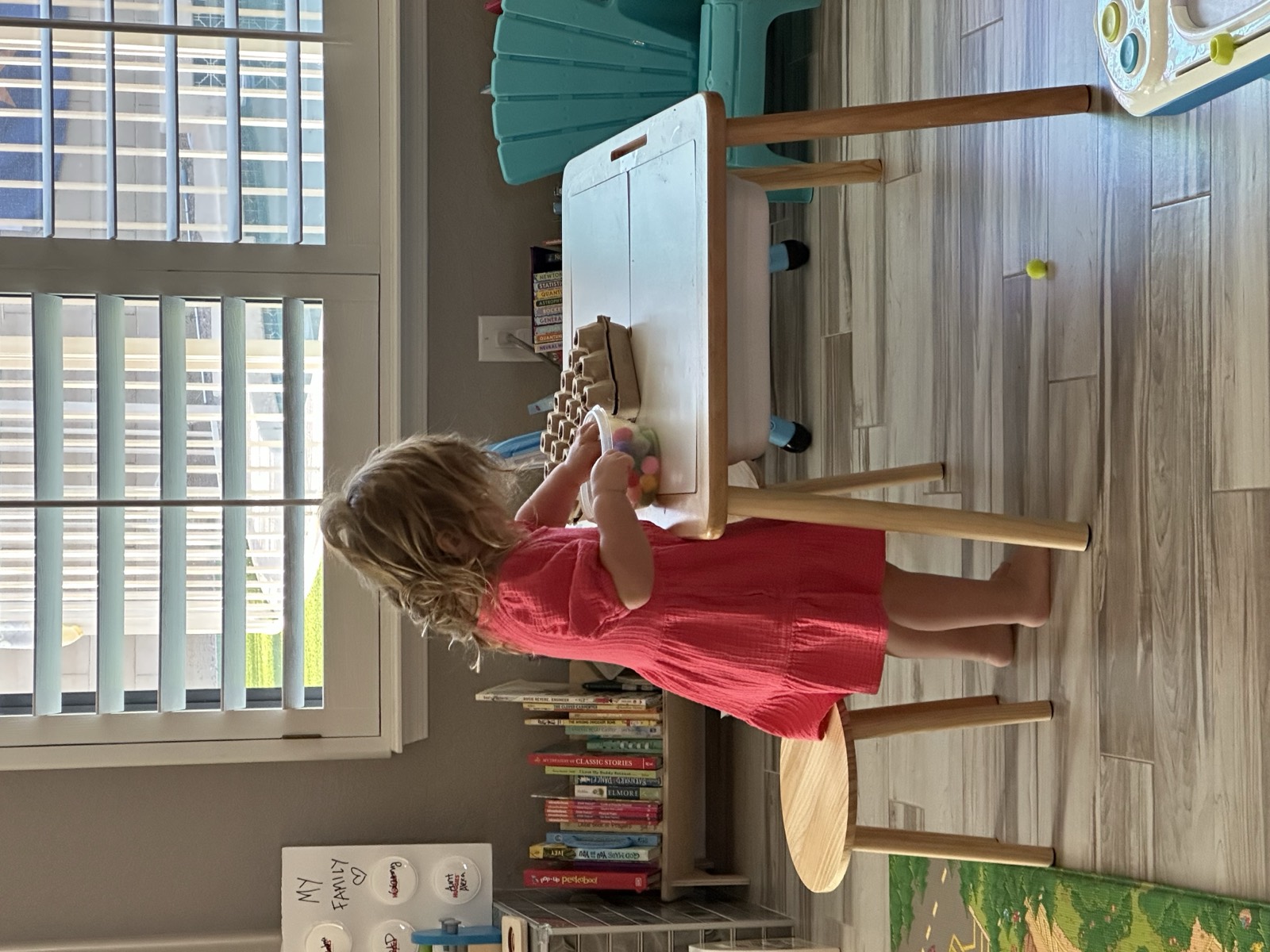 A focused toddler absorbed in independent play on the floor, building the skill one stretch at a time